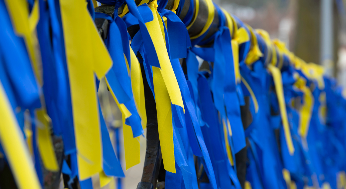 Ribbons of the Ukrainian flag tied around a railing